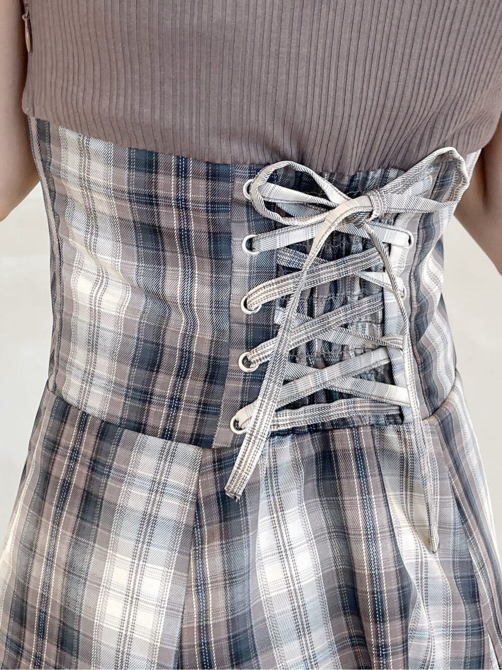 ベージュ系のワンピース、パープル系のライダースジャケット、グレー系のパンプスを着用したレディースの秋コーディネートの10枚目の写真