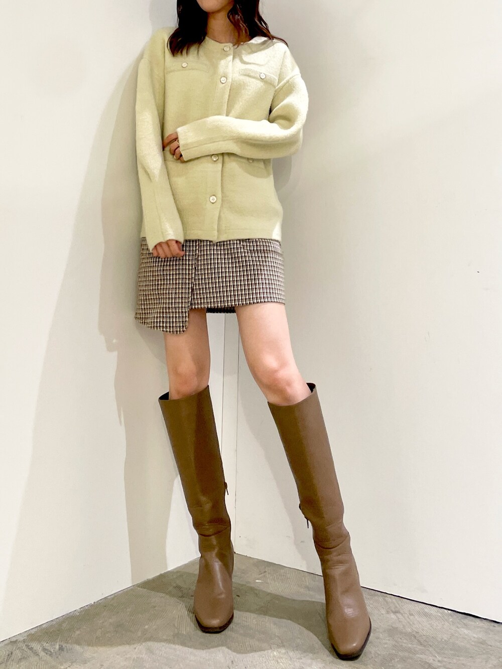 グリーン系のカーディガン/ボレロ、ブラウン系のスカート、ベージュ系のブーツを着用したレディースの秋コーディネートの4枚目の写真