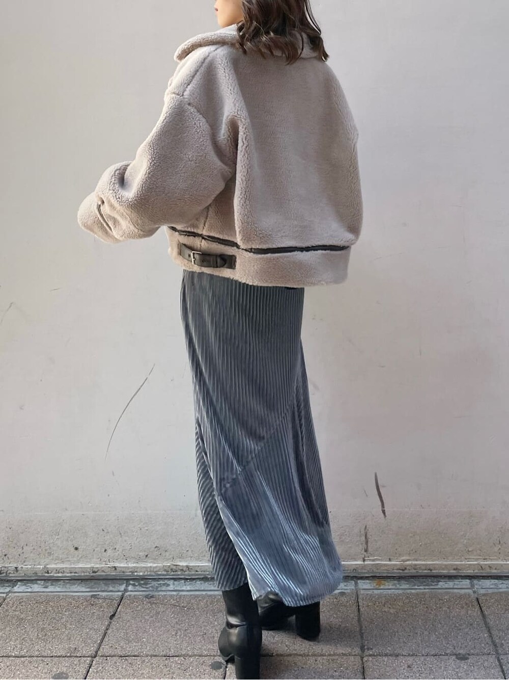 ベージュ系のブルゾン、ブラック系のブーツ、ブルー系のスカートを着用したレディースの秋コーディネートの2枚目の写真