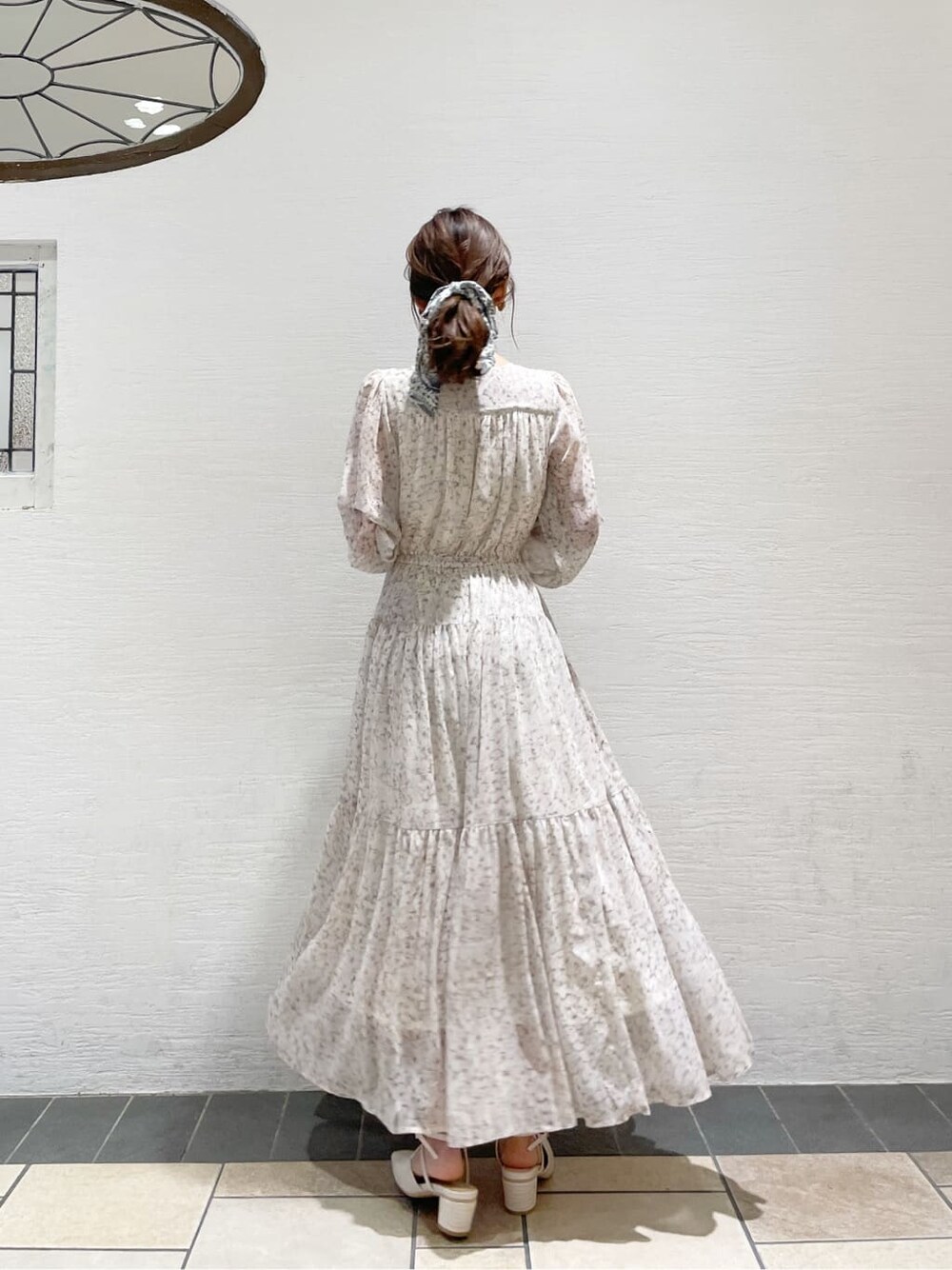 グレー系のトレンチコート、オレンジ系のワンピース、グレー系のニット/セーターを着用したレディースの冬コーディネートの3枚目の写真