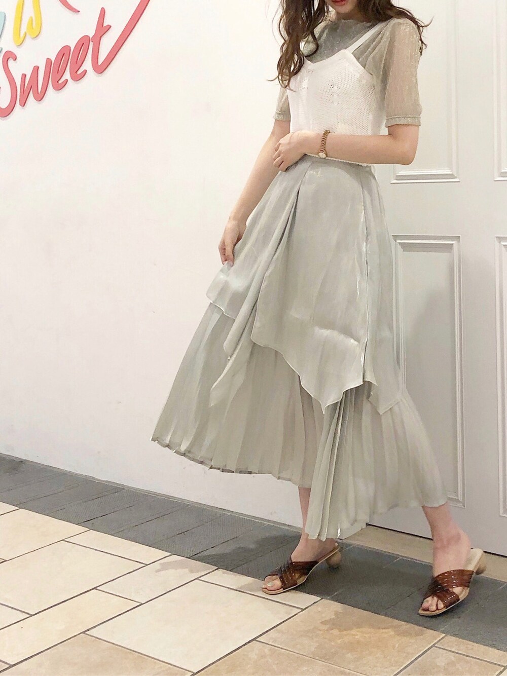 グリーン系のスカート、シルバー系のTシャツ/カットソー、ブラウン系のサンダルを着用したレディースの夏コーディネートの2枚目の写真