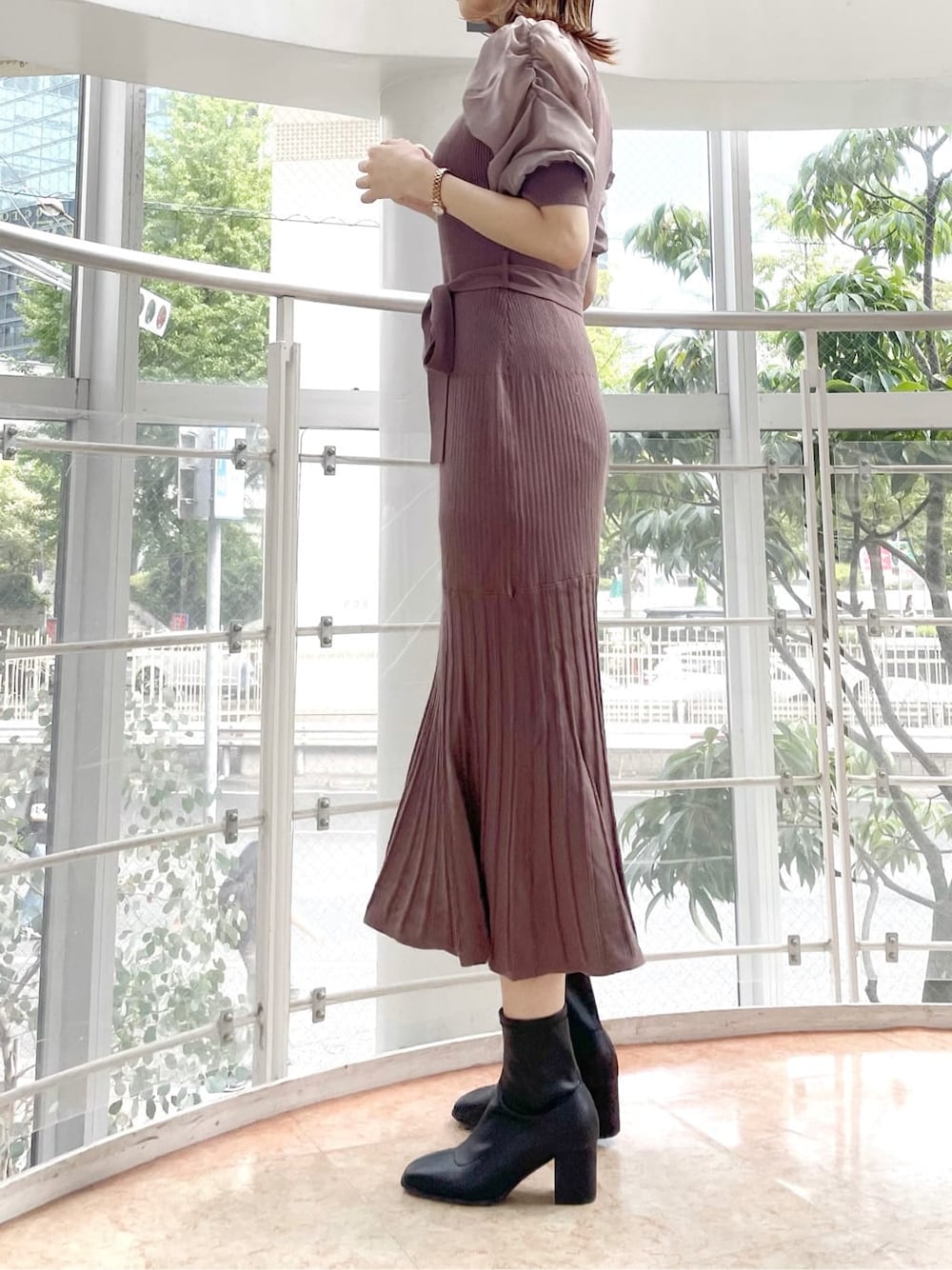 ブラウン系のワンピース、ブラック系のブーツを着用したレディースの秋コーディネートの3枚目の写真