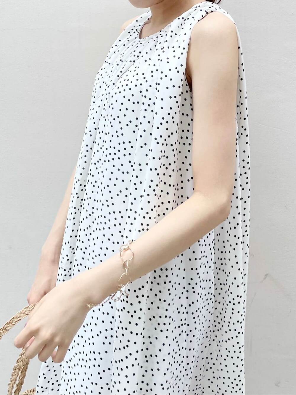 オレンジ系のサンダル、ホワイト系のワンピース、ゴールド系のブレスレットを着用したレディースの夏コーディネートの7枚目の写真