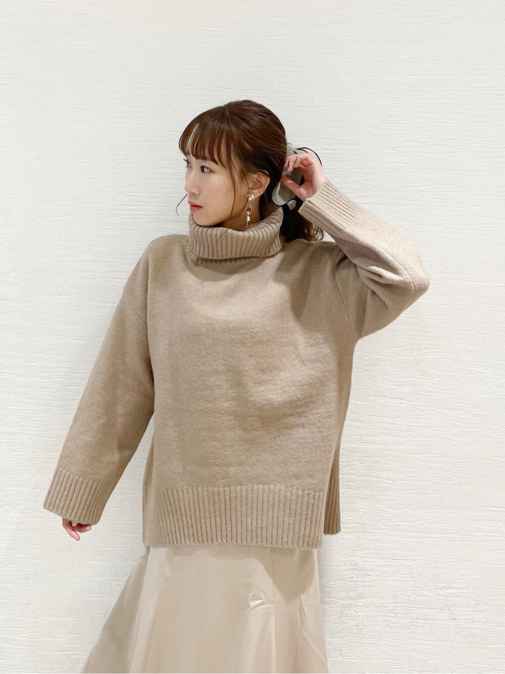 ブラウン系のブーツ、ホワイト系のスカート、ベージュ系のニット/セーターを着用したレディースの冬コーディネートの4枚目の写真