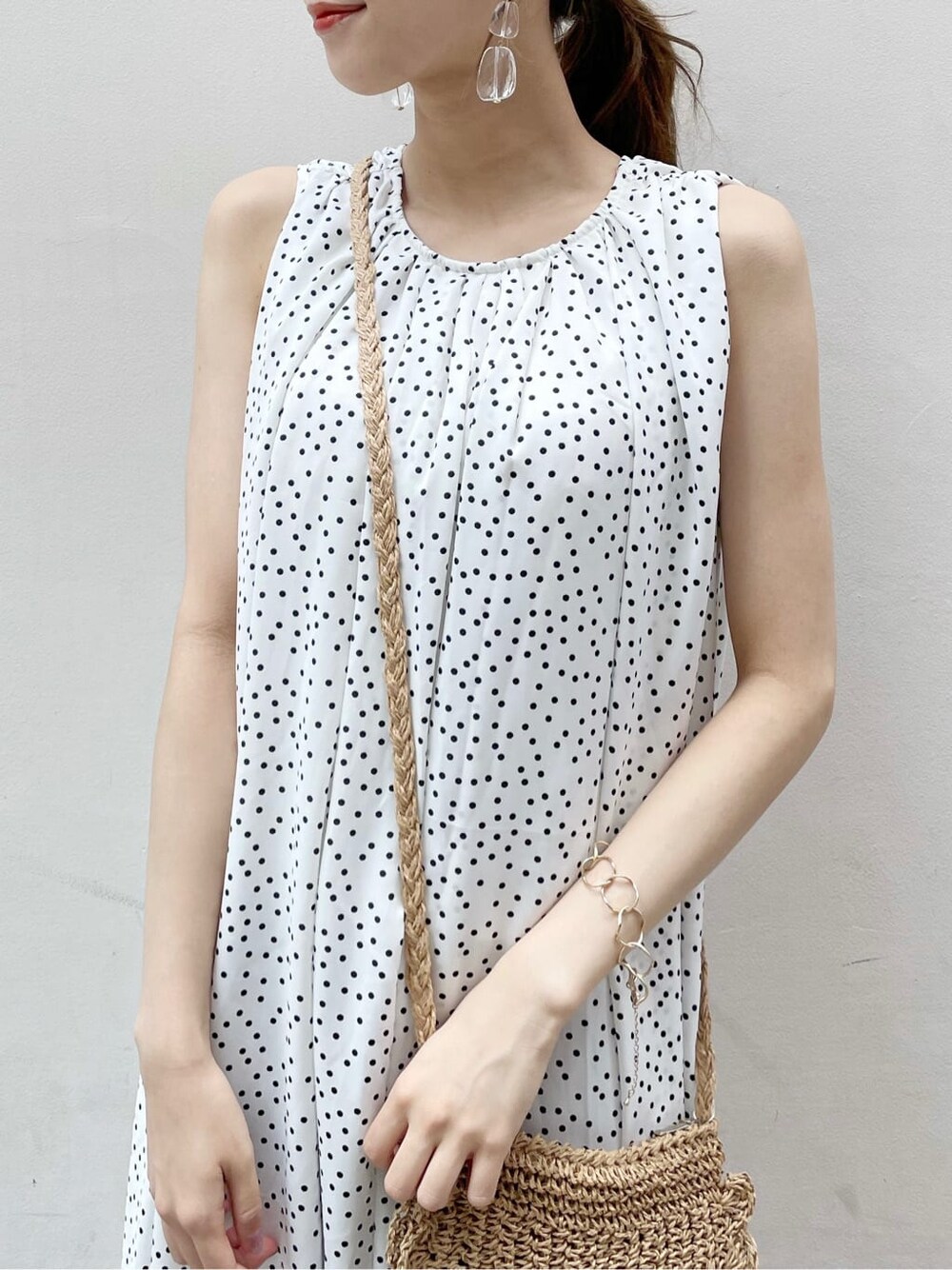 オレンジ系のサンダル、ホワイト系のワンピース、ゴールド系のブレスレットを着用したレディースの夏コーディネートの5枚目の写真