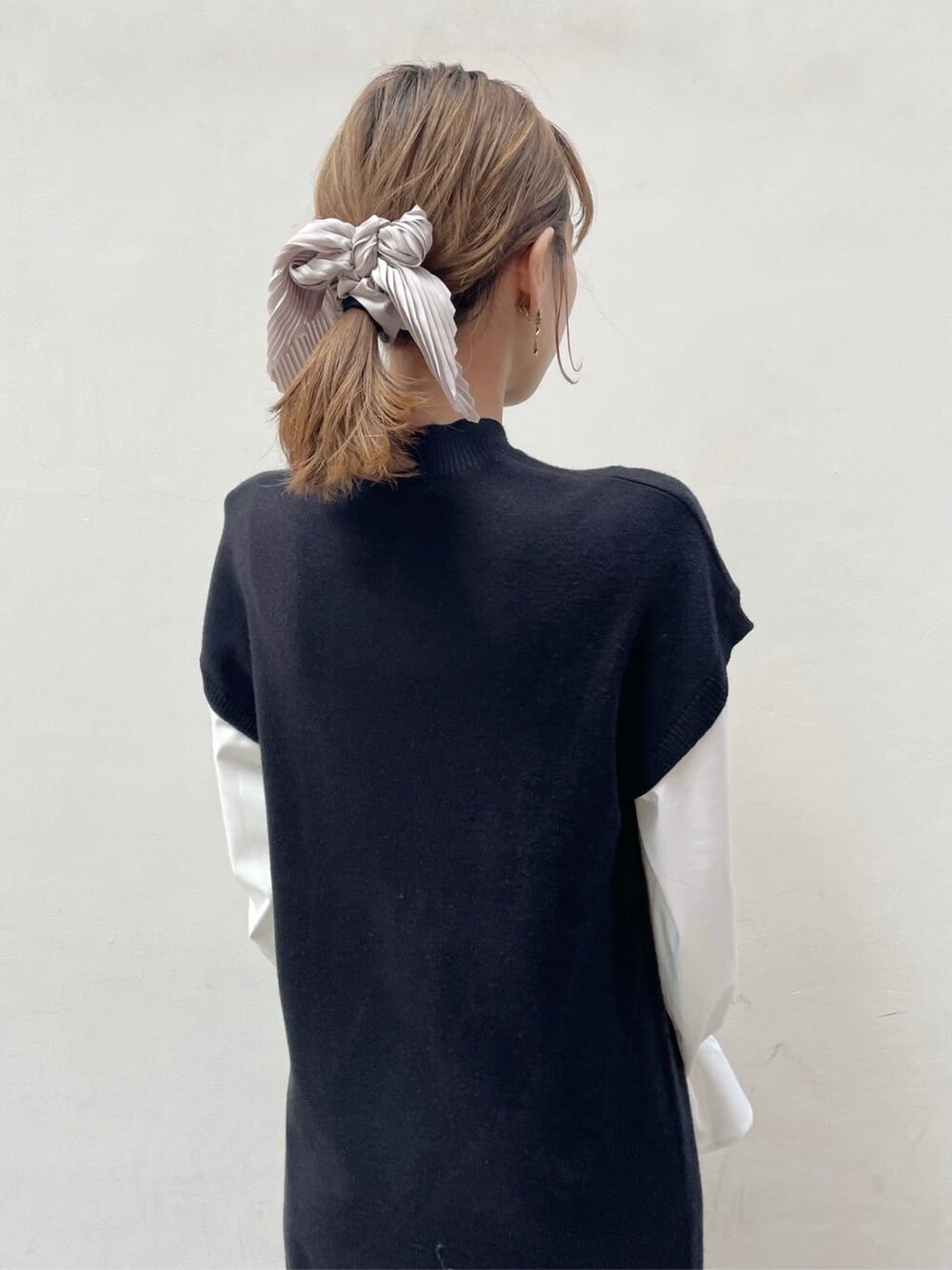 ブラック系のブーツ、ブラック系のワンピース、ベージュ系のハンドバッグを着用したレディースの秋コーディネートの7枚目の写真