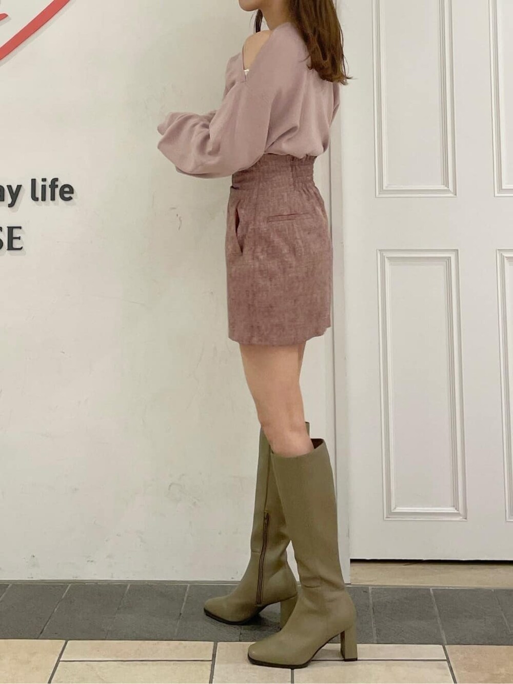 レッド系のスカート、ベージュ系のブーツ、ピンク系のニット/セーターを着用したレディースの夏コーディネートの2枚目の写真