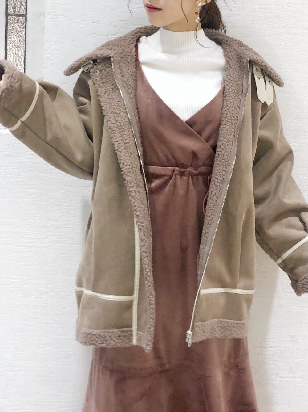 ピンク系のワンピース、ブラウン系のブーツ、ベージュ系のブルゾンを着用したレディースの秋コーディネートの3枚目の写真