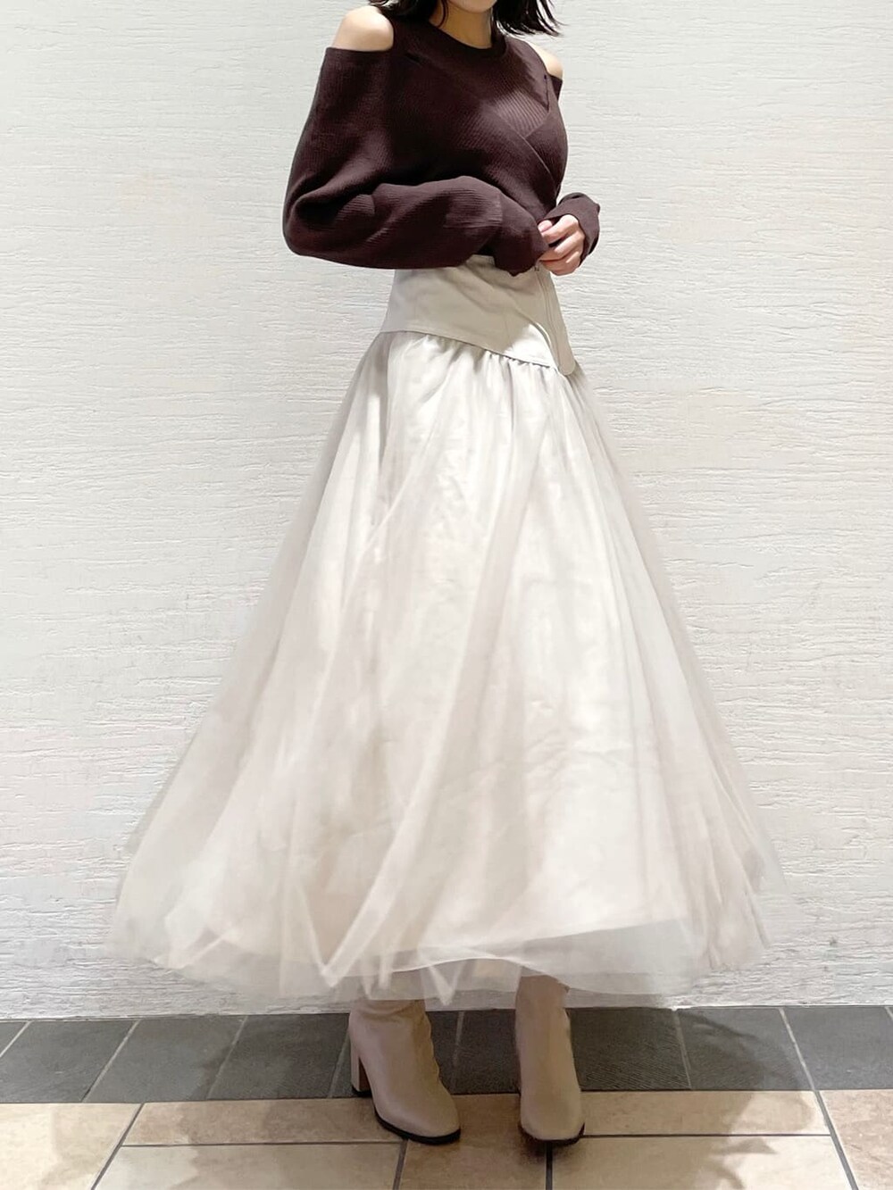 ベージュ系のスカート、ホワイト系のブルゾン、ブラウン系のニット/セーターを着用したレディースの夏コーディネートの7枚目の写真