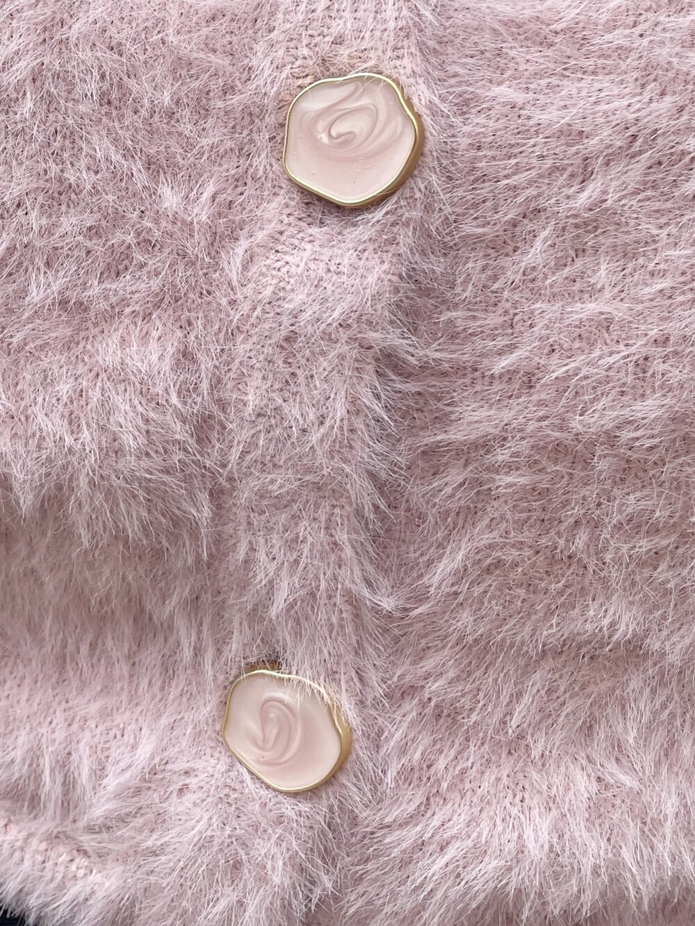 ピンク系のニット/セーター、ブラック系のスカート、ブラック系のブーツを着用したレディースの冬コーディネートの7枚目の写真