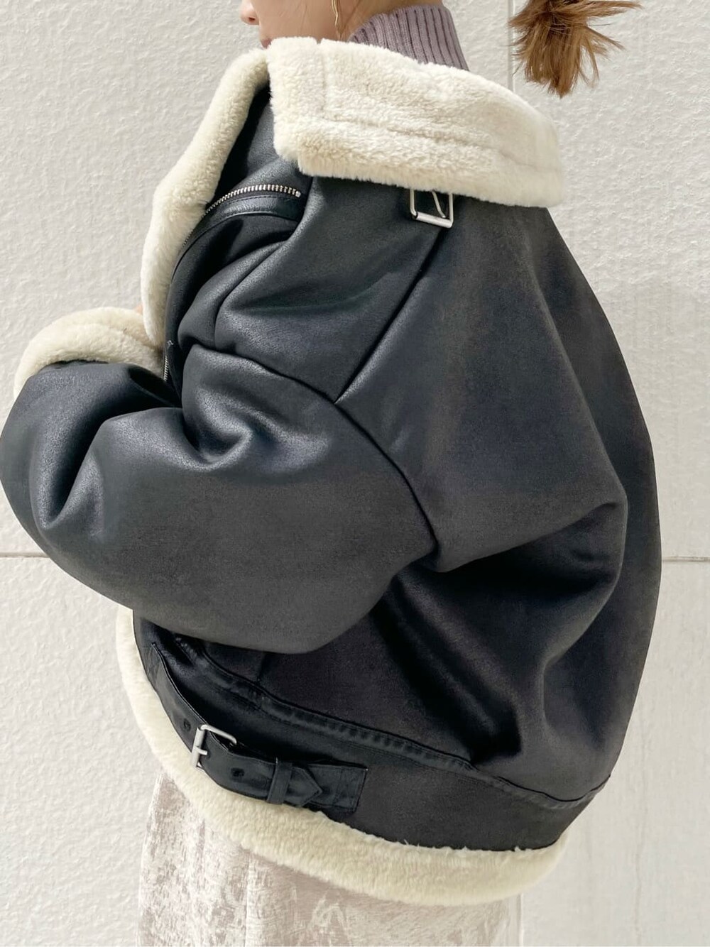 ブラック系のブルゾン、ベージュ系のスカート、ブラック系のブーツを着用したレディースの秋コーディネートの6枚目の写真