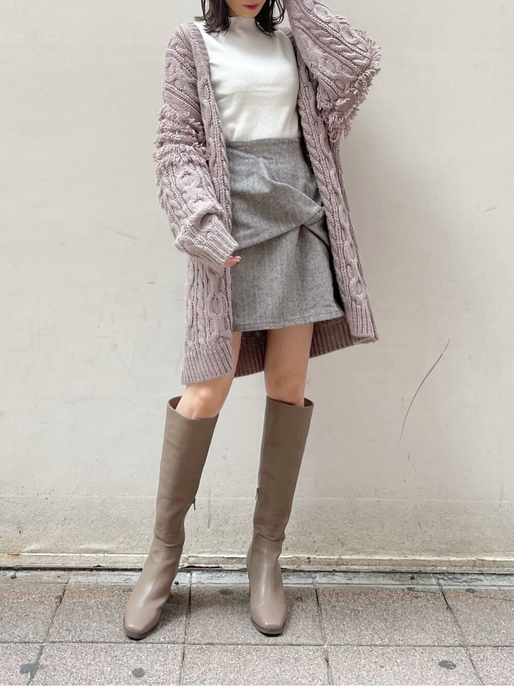 ブラウン系のスカート、ベージュ系のブーツ、ホワイト系のニット/セーターを着用したレディースの秋コーディネートの4枚目の写真