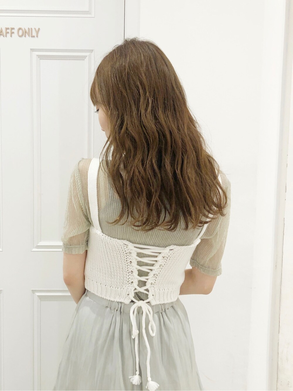 グリーン系のスカート、シルバー系のTシャツ/カットソー、ブラウン系のサンダルを着用したレディースの夏コーディネートの4枚目の写真