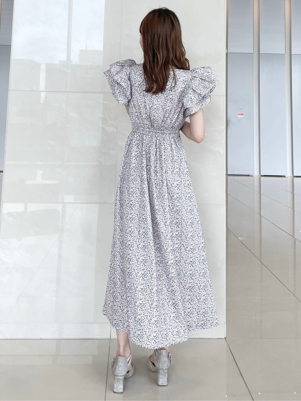 グレー系のパンプス、ホワイト系のワンピースを着用したレディースの秋コーディネートの2枚目の写真