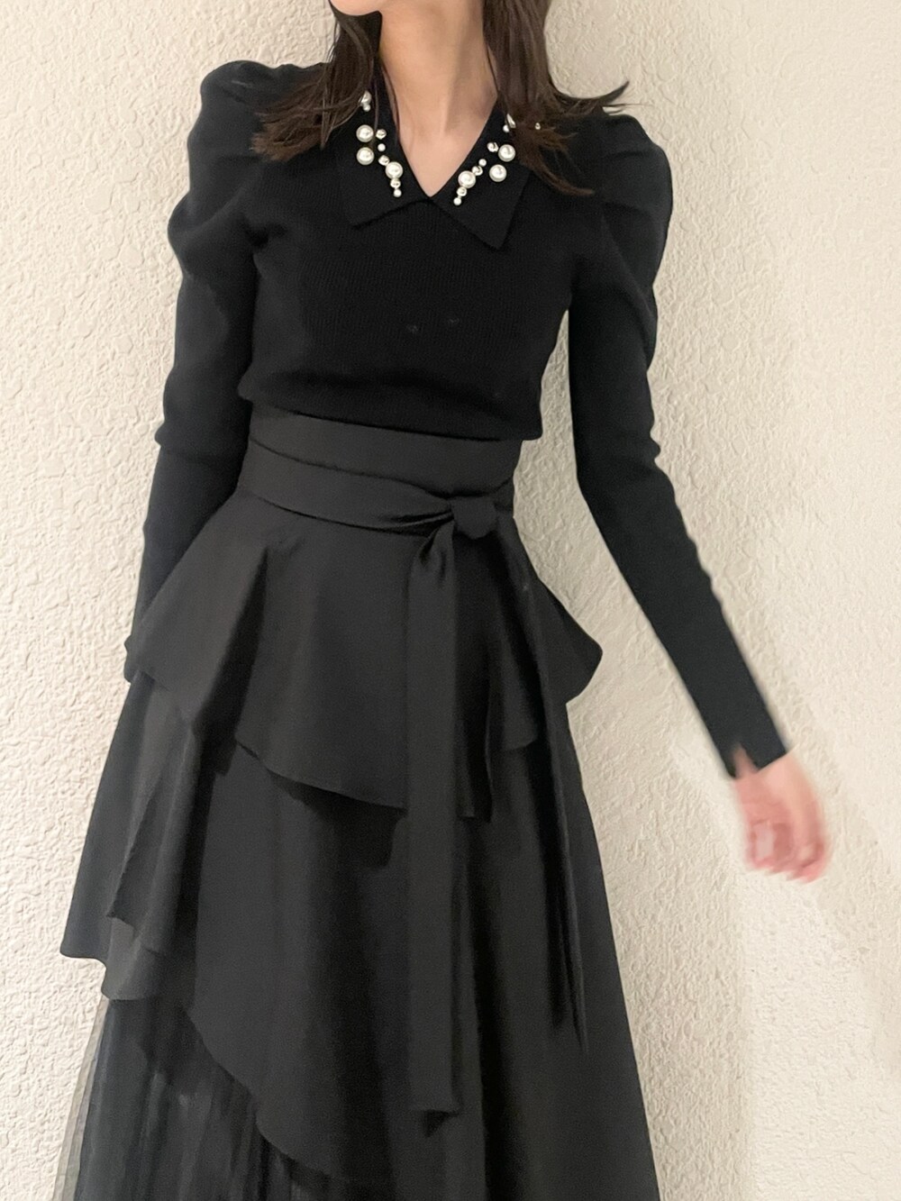 ブラック系のニット/セーター、ブラック系のブーツ、ブラック系のスカートを着用したレディースの冬コーディネートの7枚目の写真