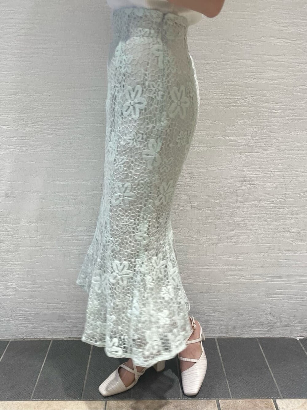 ホワイト系のニット/セーター、ブルー系のスカート、ブルー系のハンドバッグを着用したレディースの春コーディネートの9枚目の写真