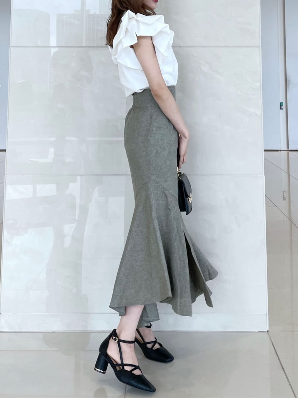 ホワイト系のシャツ/ブラウス、グリーン系のスカート、ブラック系のパンプスを着用したレディースの秋コーディネートの2枚目の写真