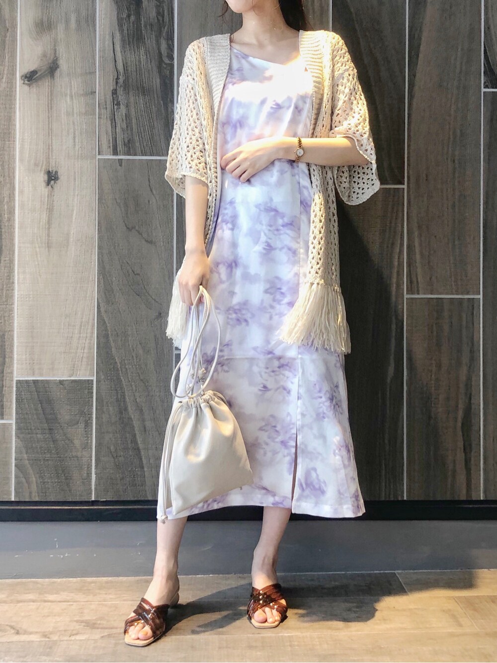 ブラウン系のサンダル、ベージュ系のカーディガン/ボレロ、パープル系のワンピースを着用したレディースの夏コーディネートの2枚目の写真