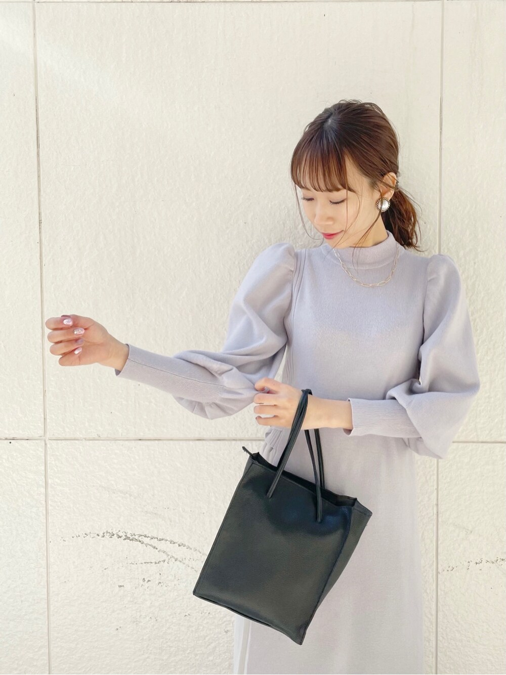 ブラック系のブーツ、ブラック系のハンドバッグ、グレー系のワンピースを着用したレディースの冬コーディネートの5枚目の写真