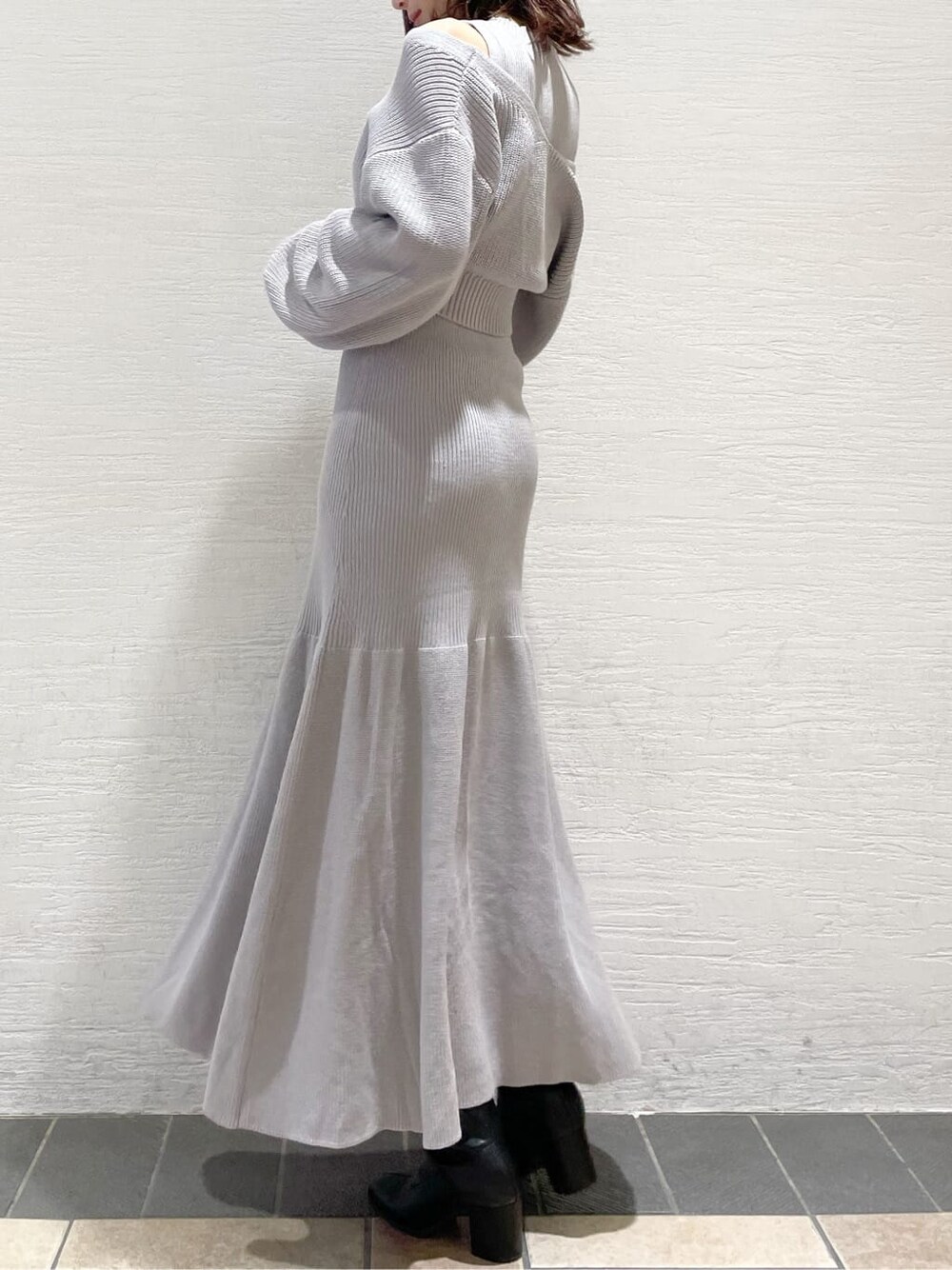 ブラック系のブーツ、グレー系のワンピースを着用したレディースの冬コーディネートの2枚目の写真