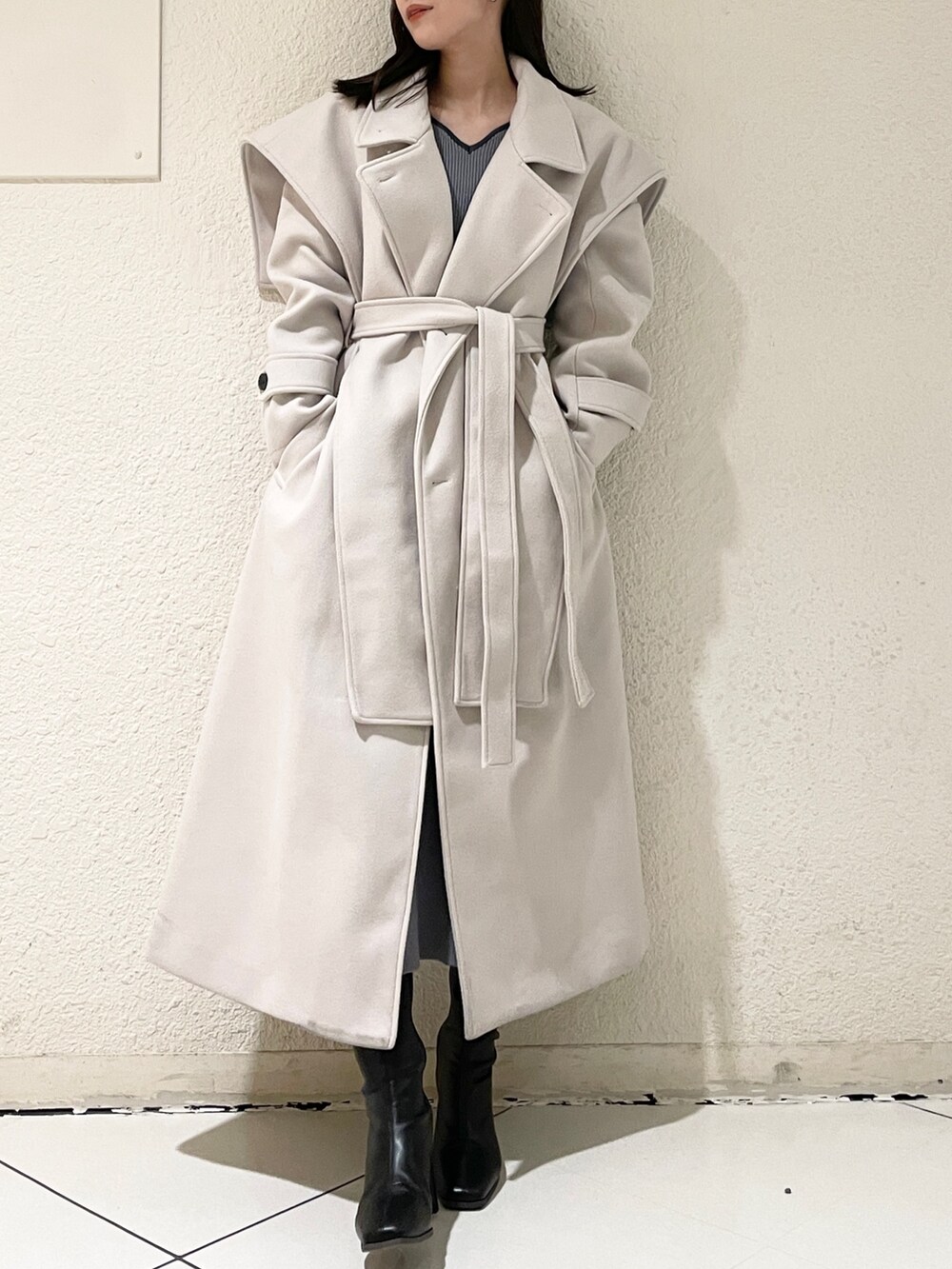 ホワイト系のその他アウター、ブラック系のブーツ、グレー系のワンピースを着用したレディースの冬コーディネートの2枚目の写真