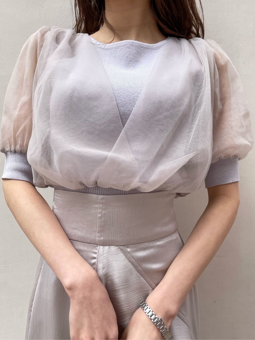 パープル系のニット/セーター、グレー系のスカート、ホワイト系のパンプスを着用したレディースの春コーディネートの5枚目の写真