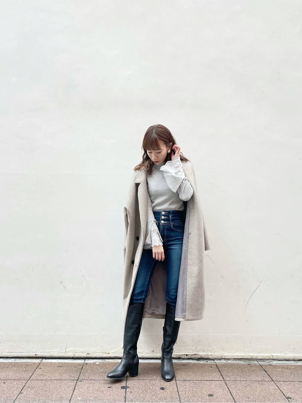 ブルー系のデニムパンツ、ブラック系のブーツ、グレー系のニット/セーターを着用したレディースの冬コーディネートの4枚目の写真