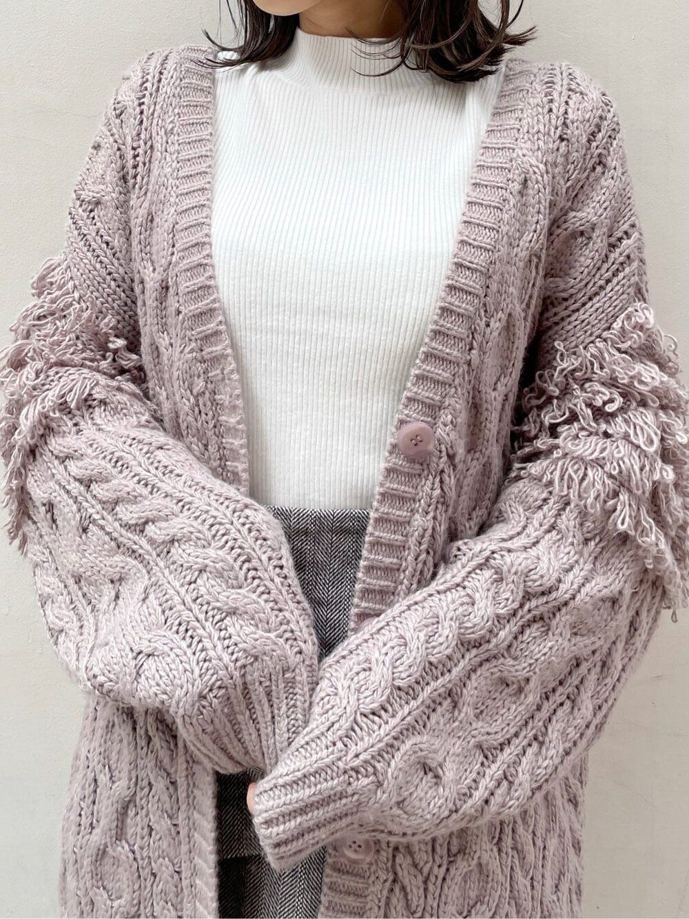 ブラウン系のスカート、ベージュ系のブーツ、ホワイト系のニット/セーターを着用したレディースの秋コーディネートの5枚目の写真