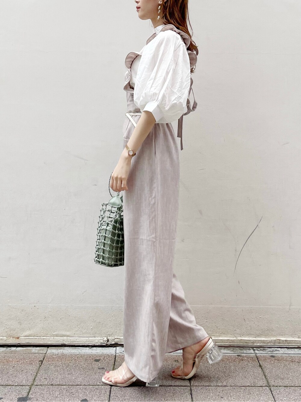 ブラウン系のサロペット/オーバーオール、ホワイト系のシャツ/ブラウス、グリーン系のショルダーバッグを着用したレディースの夏コーディネートの3枚目の写真