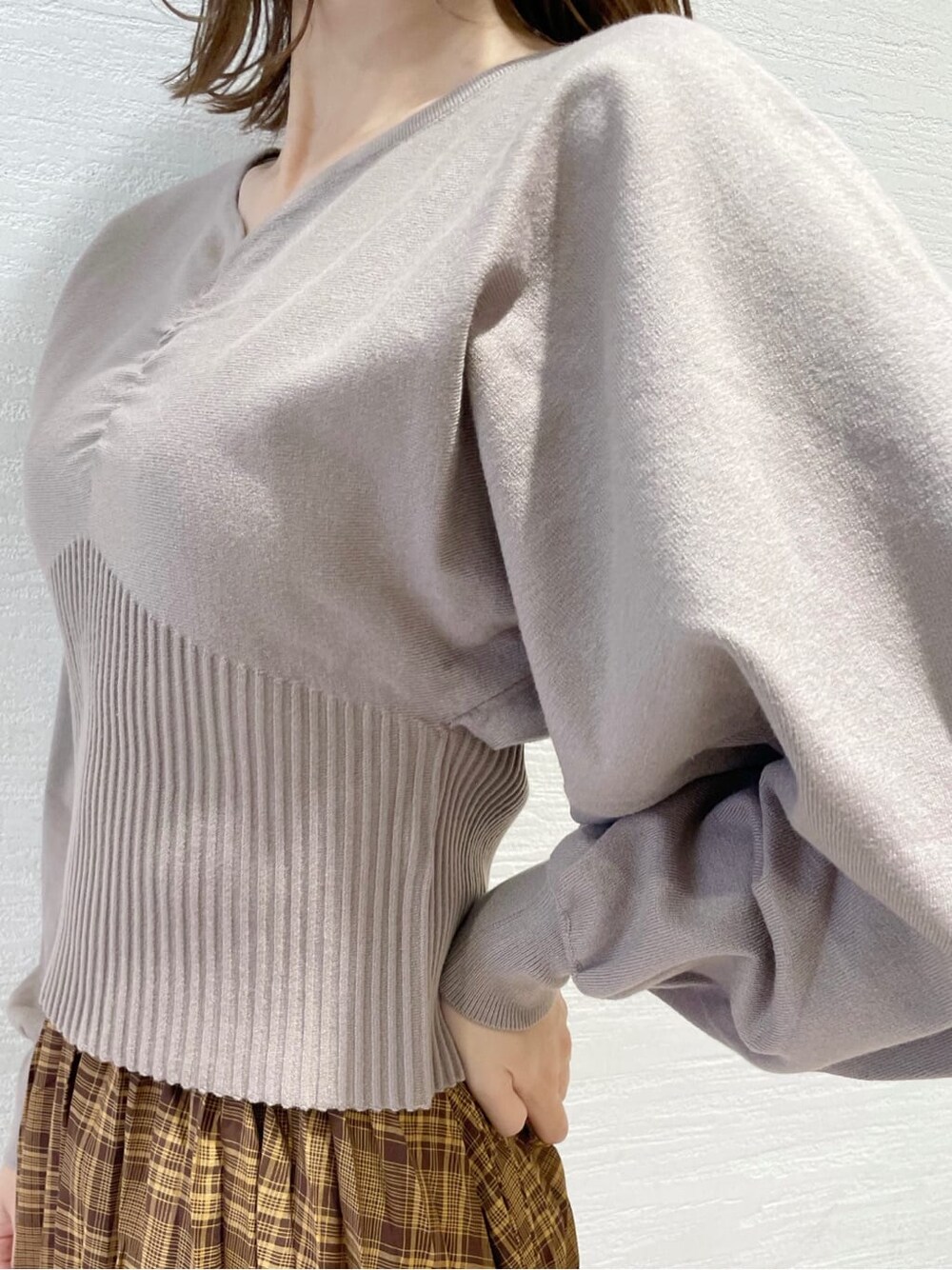 ブラウン系のスカート、ベージュ系のTシャツ/カットソー、ブラック系のブーツを着用したレディースの秋コーディネートの8枚目の写真
