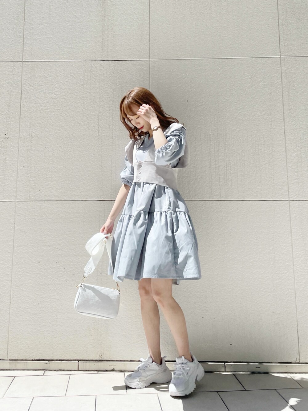 ホワイト系のスニーカー、ホワイト系のショルダーバッグ、ブルー系のチュニックを着用したレディースの春コーディネートの3枚目の写真
