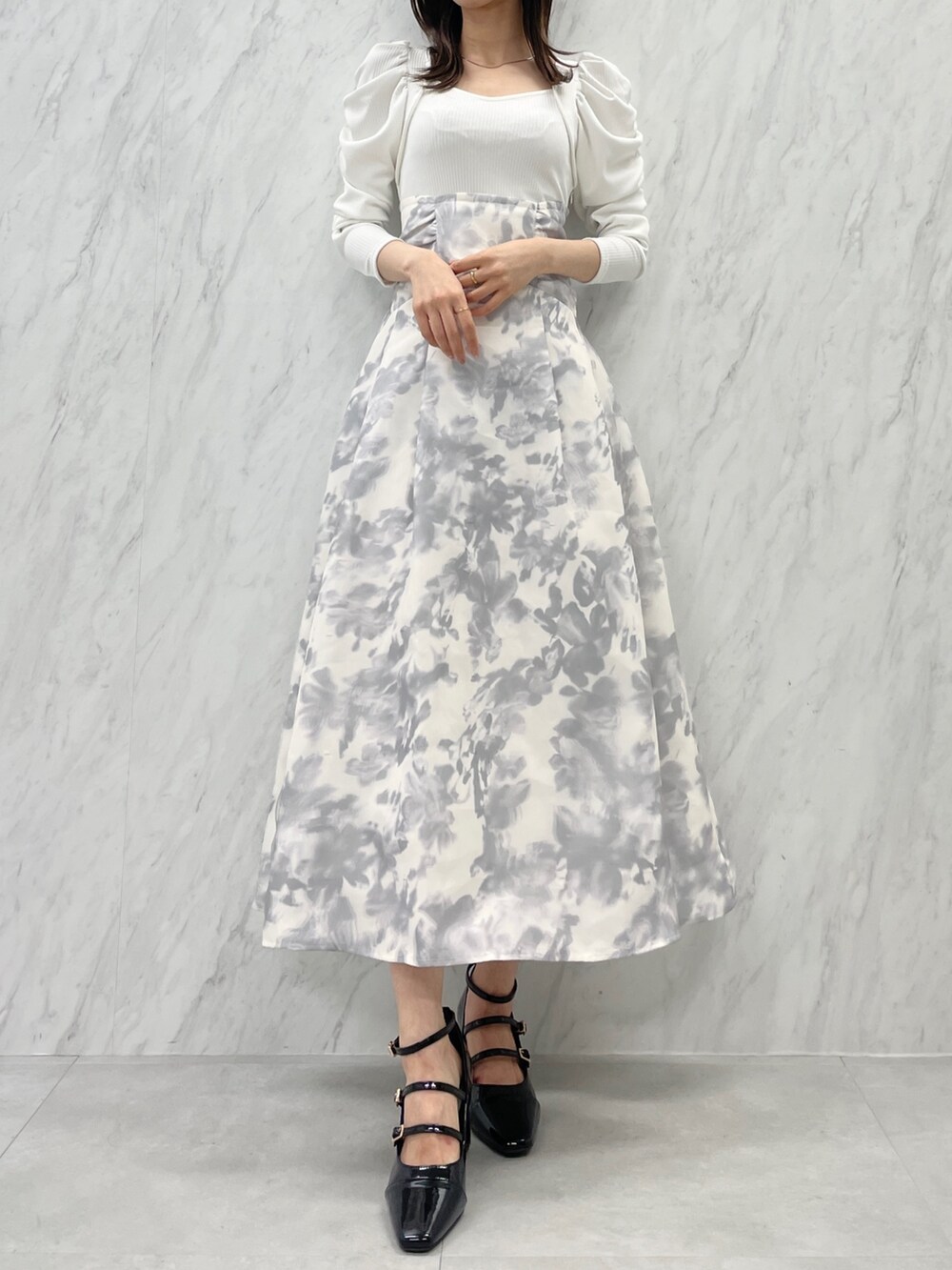 ホワイト系のワンピース、ブラック系のパンプスを着用したレディースの秋コーディネートの2枚目の写真