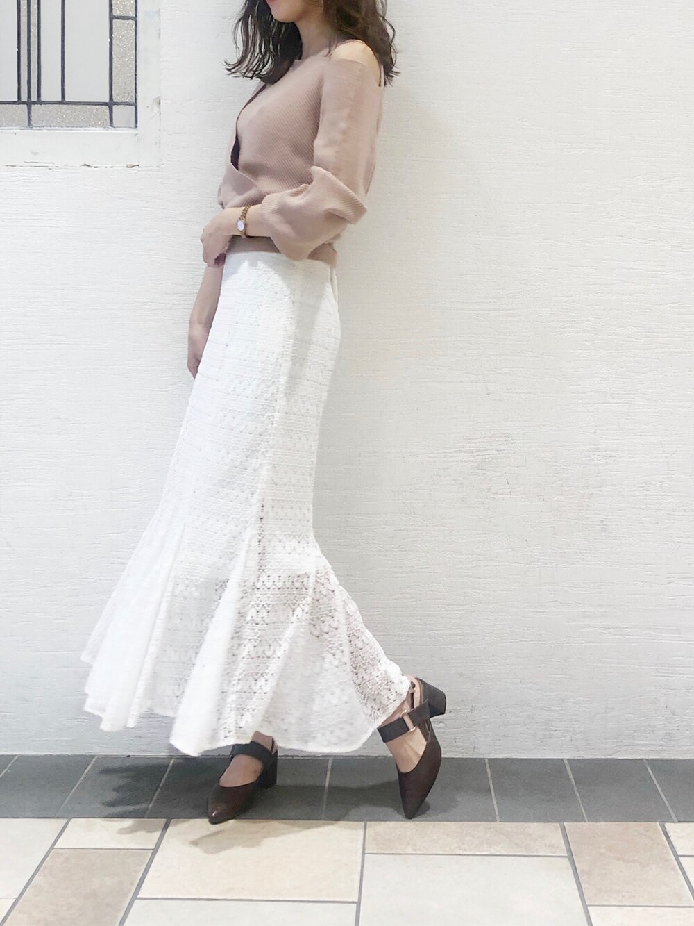 ブラウン系のパンプス、ベージュ系のニット/セーター、ホワイト系のスカートを着用したレディースの夏コーディネートの3枚目の写真