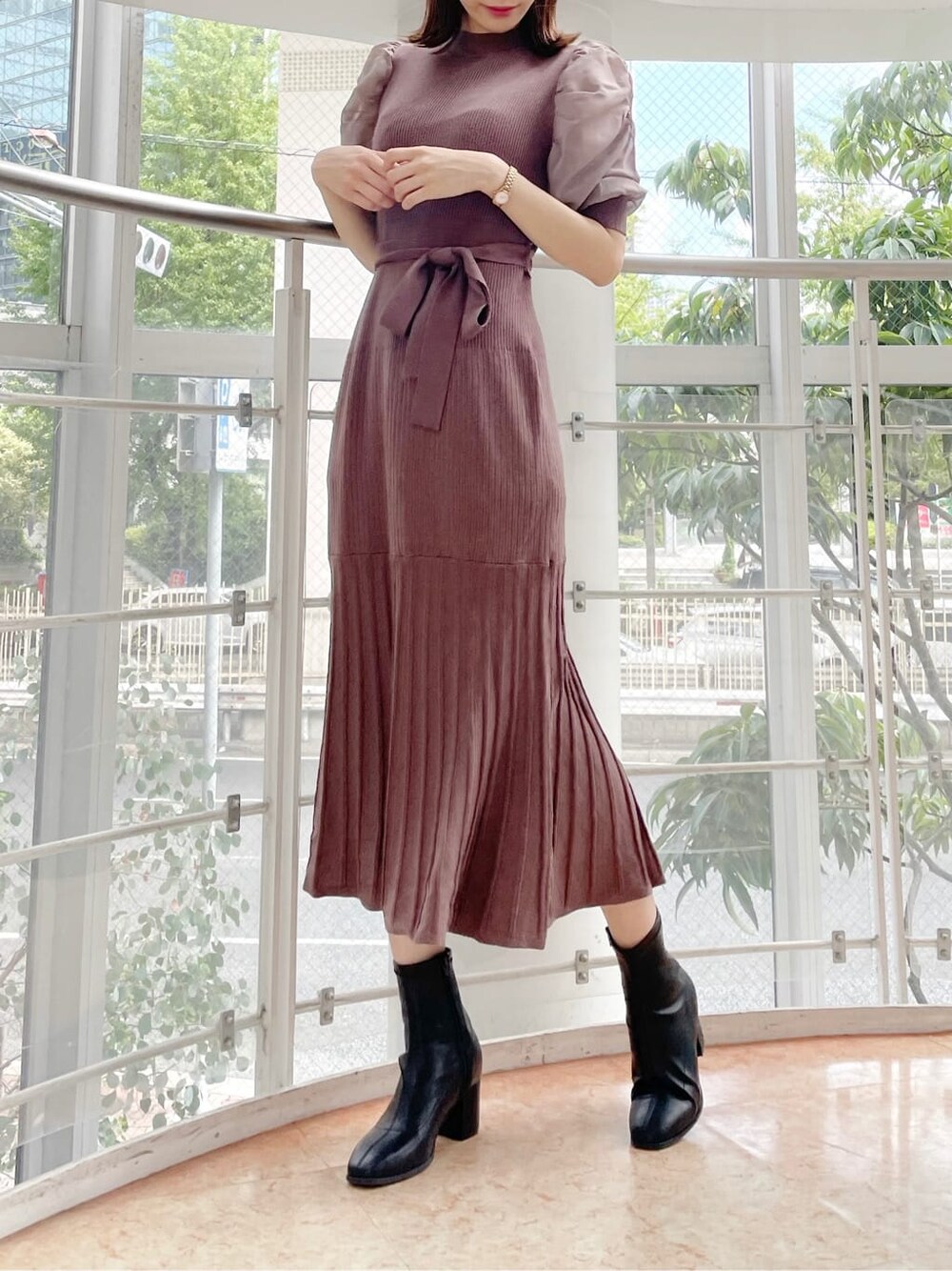 ブラウン系のワンピース、ブラック系のブーツを着用したレディースの秋コーディネートの2枚目の写真