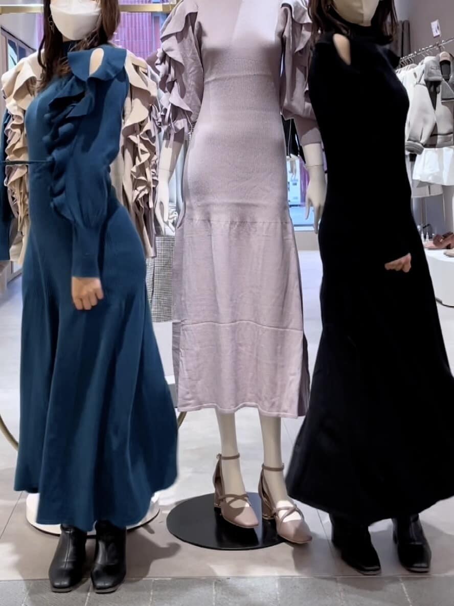 グリーン系のワンピース、ブラック系のブーツ、ホワイト系のブルゾンを着用したレディースの秋コーディネートの3枚目の写真