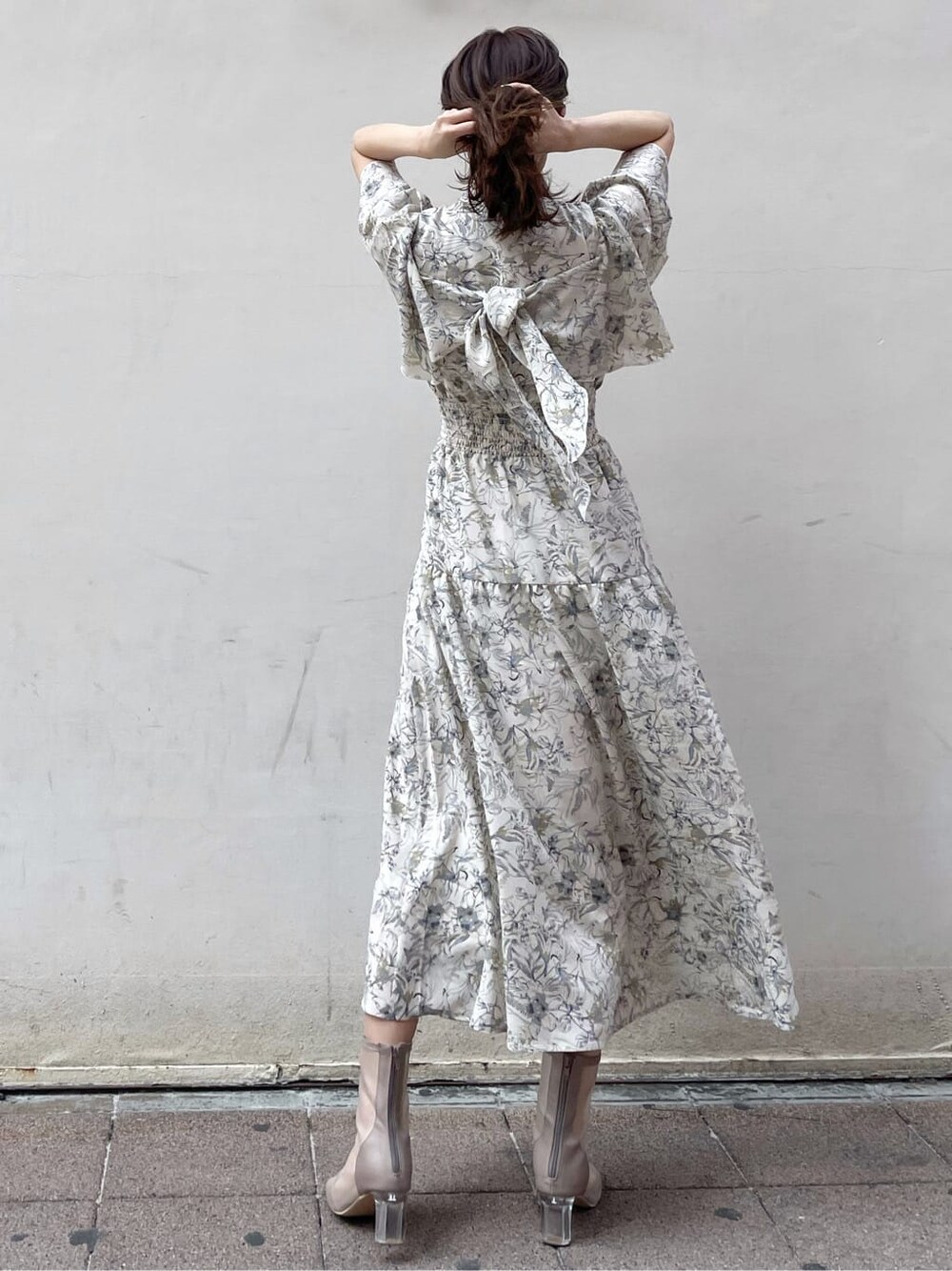 ベージュ系のトレンチコート、ホワイト系のワンピース、ベージュ系のブーツを着用したレディースの春コーディネートの6枚目の写真