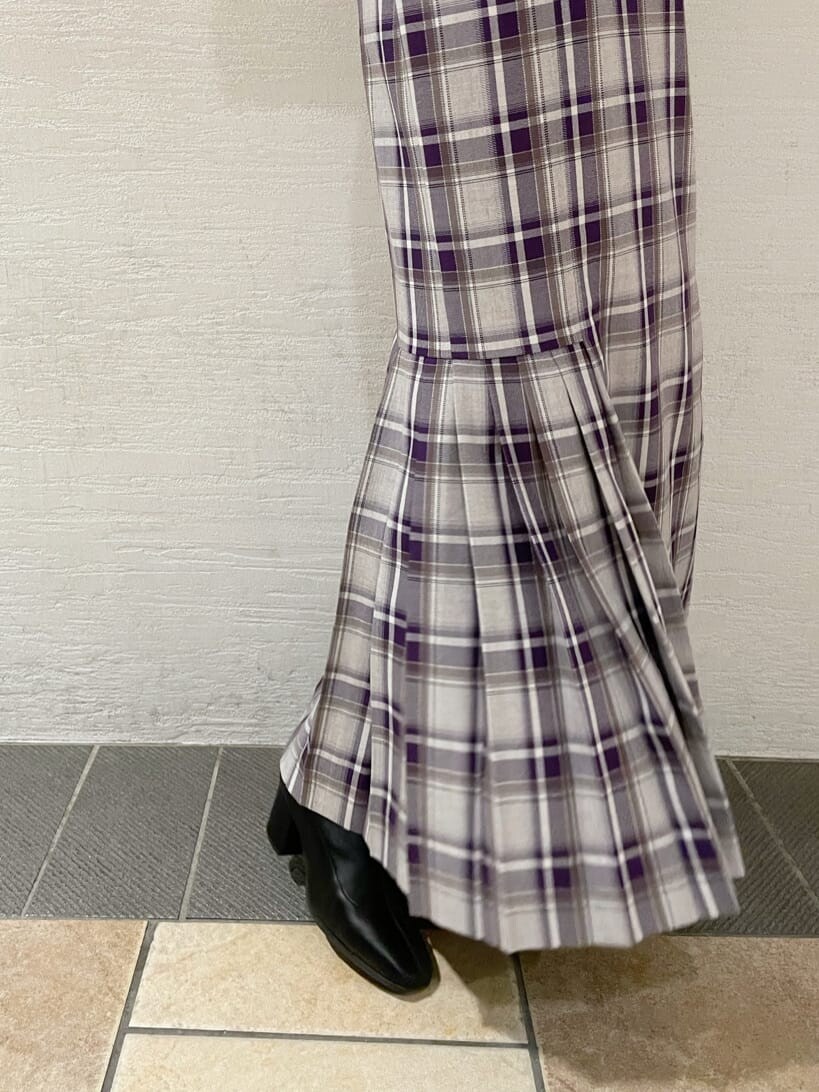 ブラック系のブーツ、ホワイト系のチェスターコート、パープル系のジャンパースカートを着用したレディースの冬コーディネートの10枚目の写真