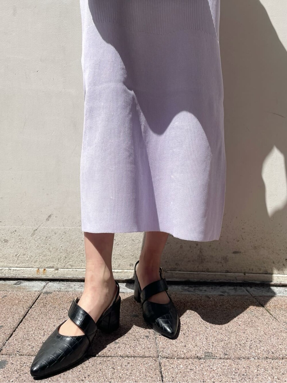 パープル系のワンピース、ブラック系のパンプス、ブラック系のハンドバッグを着用したレディースの春コーディネートの10枚目の写真