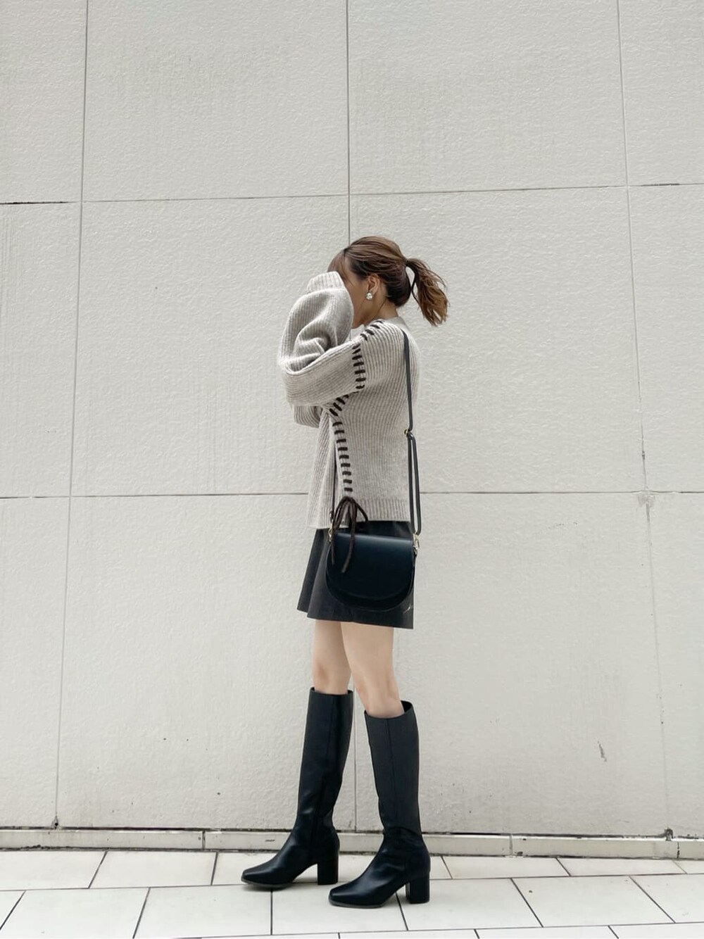 ブラック系のショルダーバッグ、グレー系のその他パンツ、ブラック系のブーツを着用したレディースの冬コーディネートの2枚目の写真