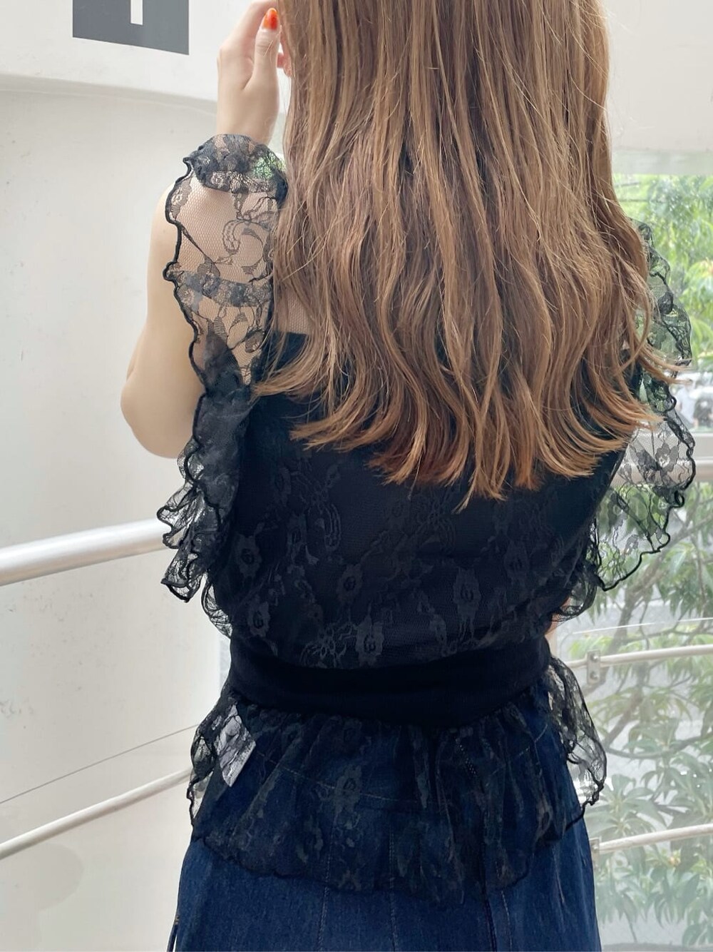 ブラック系のハンドバッグ、ブラック系のシャツ/ブラウス、ブルー系のスカートを着用したレディースの夏コーディネートの4枚目の写真