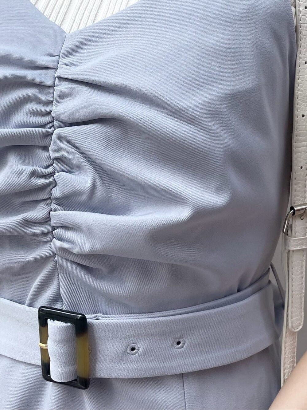 ブルー系のワンピース、ホワイト系のニット/セーター、ホワイト系のパンプスを着用したレディースの春コーディネートの8枚目の写真