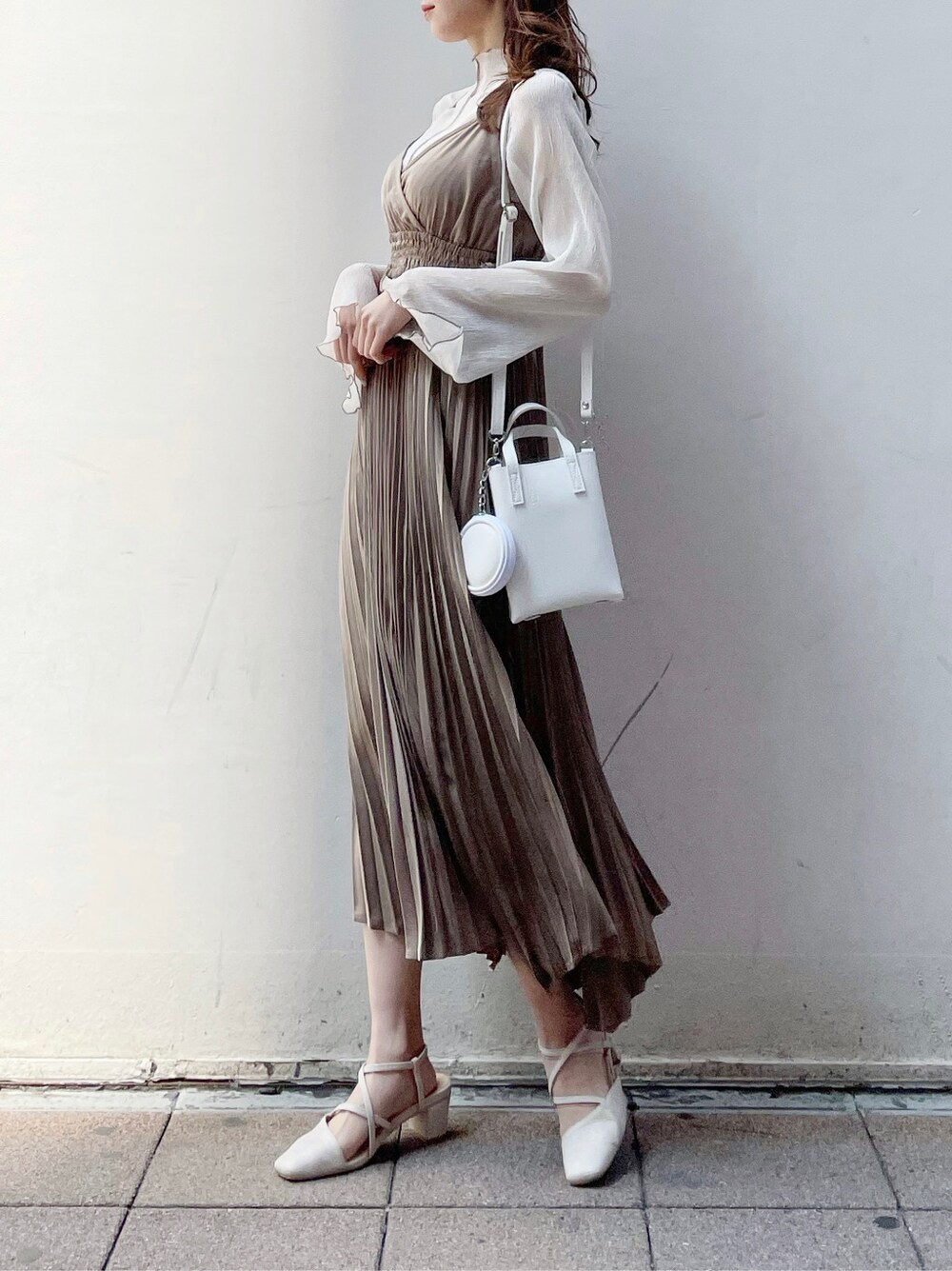 ベージュ系のワンピース、ベージュ系のTシャツ/カットソー、ホワイト系のパンプスを着用したレディースの春コーディネートの5枚目の写真