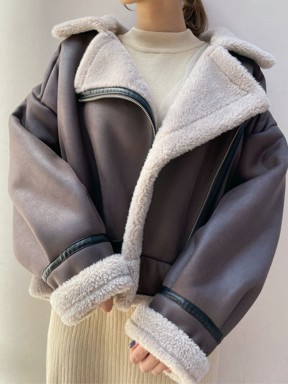 ブラウン系のブーツ、ブラウン系のブルゾン、ベージュ系のワンピースを着用したレディースの秋コーディネートの3枚目の写真