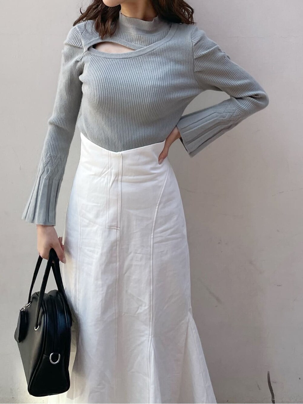 ホワイト系のスカート、ブラック系のブーツ、グリーン系のニット/セーターを着用したレディースの冬コーディネートの3枚目の写真