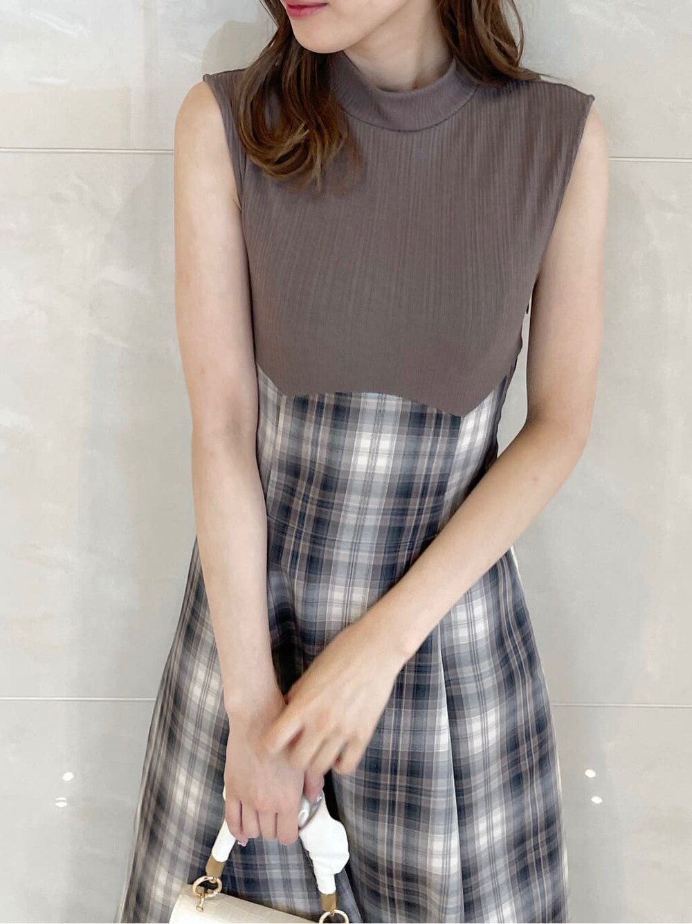 ベージュ系のワンピース、パープル系のライダースジャケット、グレー系のパンプスを着用したレディースの秋コーディネートの8枚目の写真