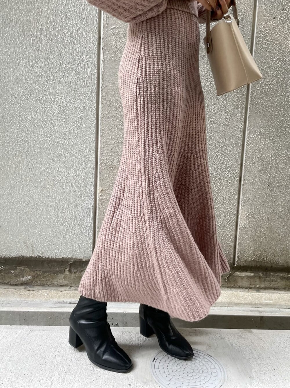 ベージュ系のワンピース、ブラック系のブーツ、ベージュ系のハンドバッグを着用したレディースの秋コーディネートの10枚目の写真