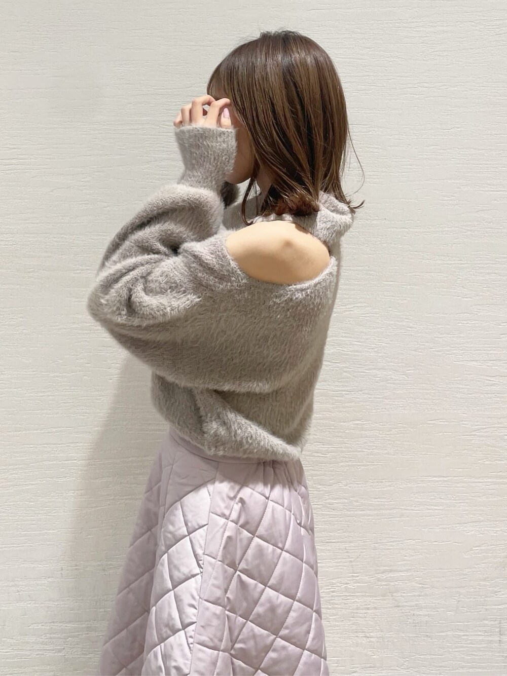 ピンク系のスカート、ブラック系のブーツ、ベージュ系のニット/セーターを着用したレディースの秋コーディネートの7枚目の写真