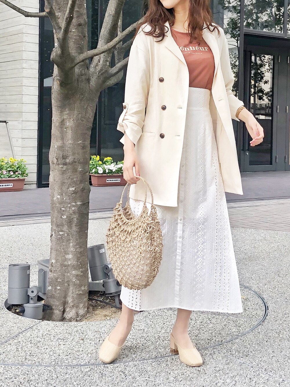 ベージュ系のハンドバッグ、ホワイト系のテーラードジャケット、ホワイト系のパンプスを着用したレディースの春コーディネートの2枚目の写真