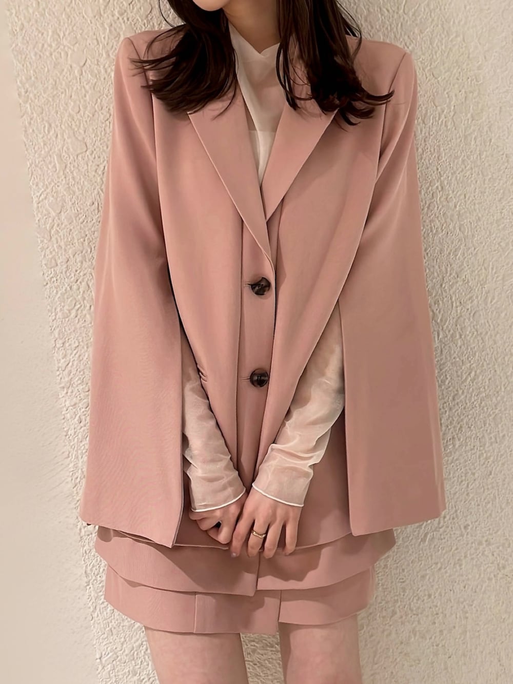 ピンク系のテーラードジャケット、ピンク系のスカート、ホワイト系のブーツを着用したレディースの冬コーディネートの7枚目の写真