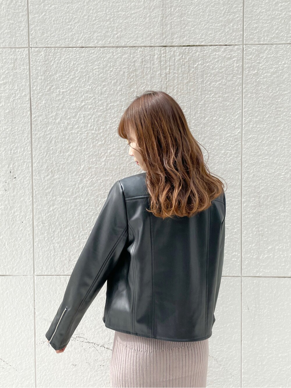 ベージュ系のワンピース、ブラック系のライダースジャケット、ブラック系のパンプスを着用したレディースの冬コーディネートの7枚目の写真